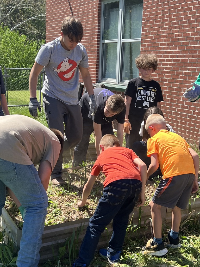 several students touching the garden bed and dirt