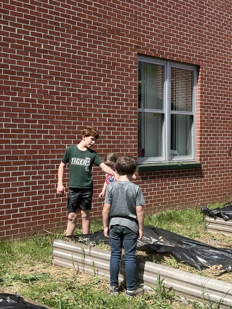 student pointing to younger students to show them the garden