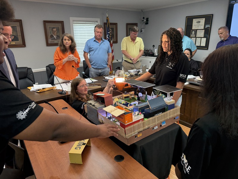 Dr. Bennett Jones and the RRGSD Board of Trustees look on as the Kidwind team presents their Smart Home at the meeting