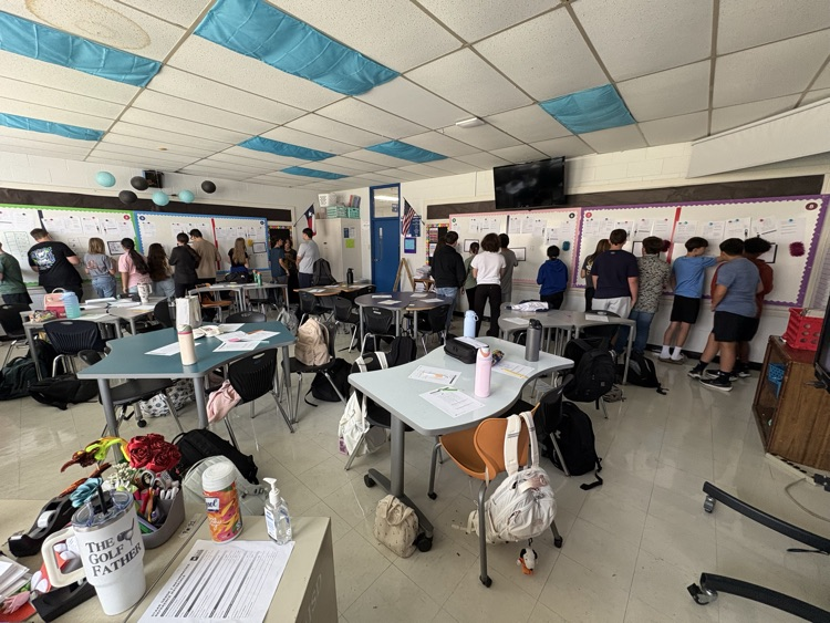 students in math classroom at the boards completing their lesson