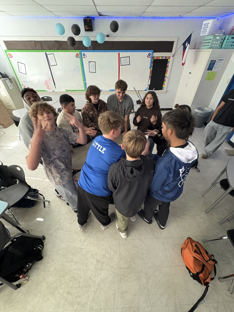 students in a circle passing a container around