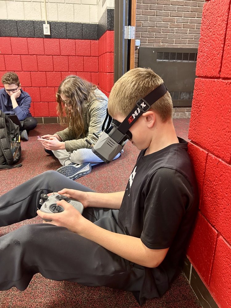 Students engaged with drone headsets and controllers at John Adams  Middle School.
