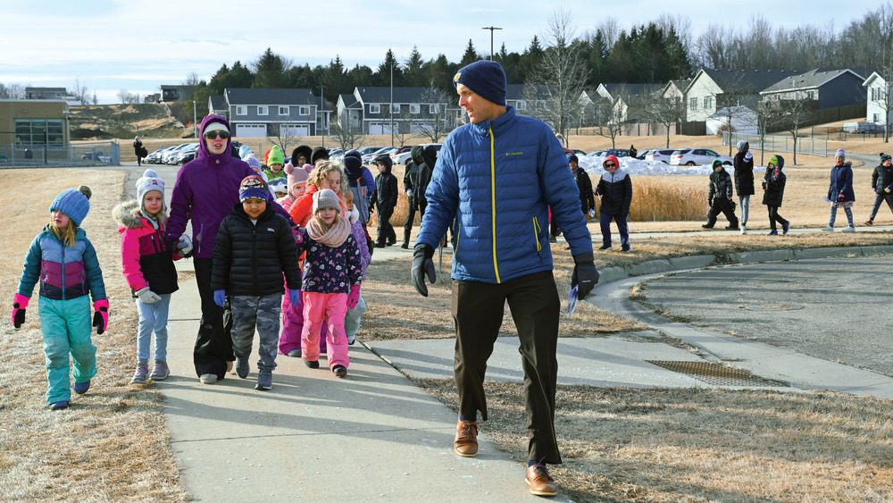 kids and staff walk together on a sidewalk