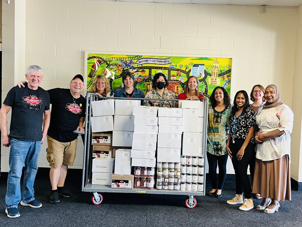 A cart with donations of food, with people standing behind