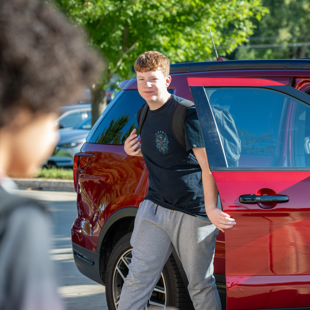 Student getting out of car to head into the school building