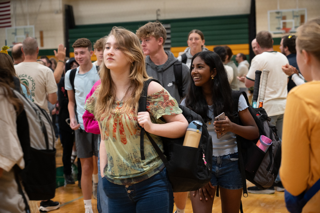 Student walking in and smiling.
