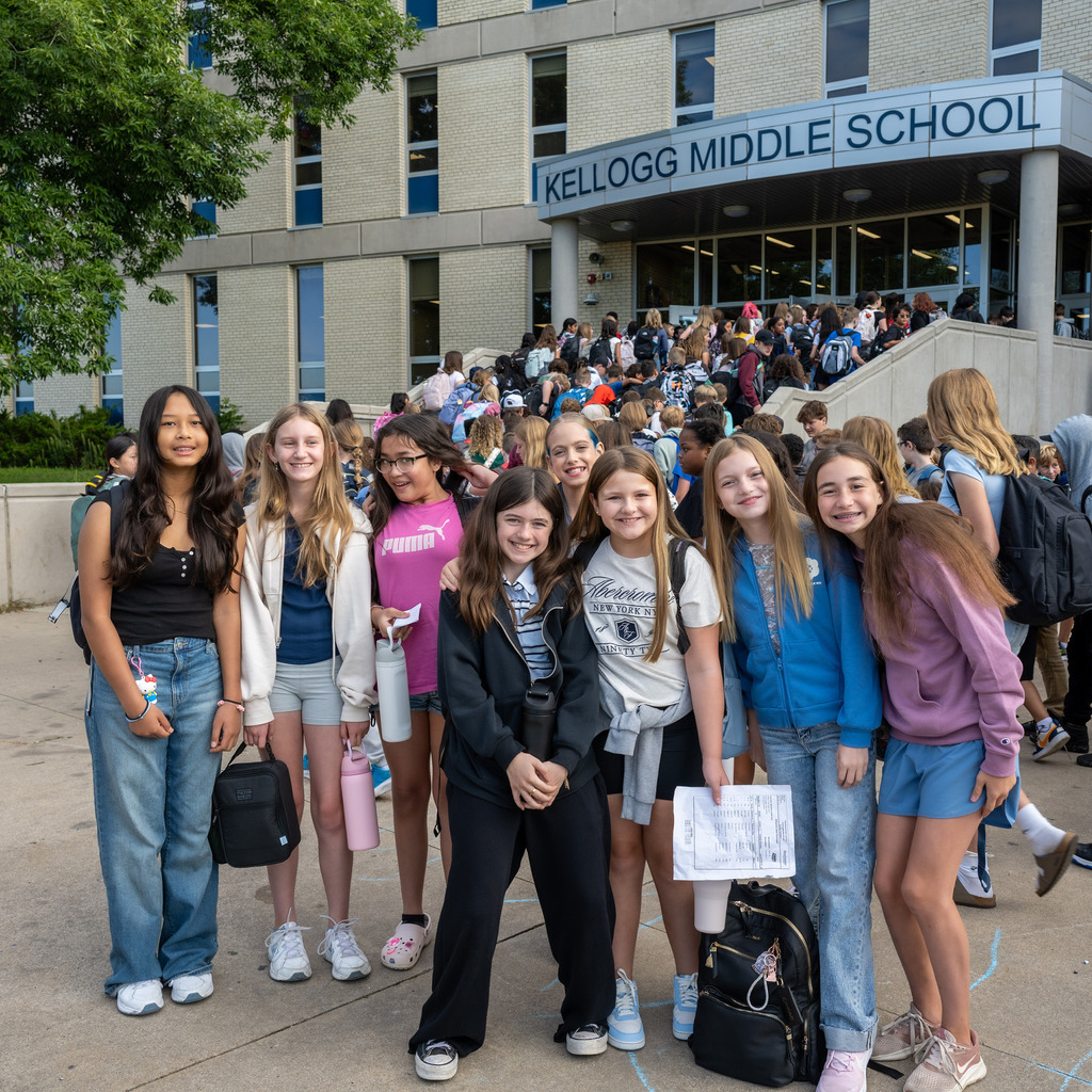 A large group of students posing in front of the school before the first bell rings.