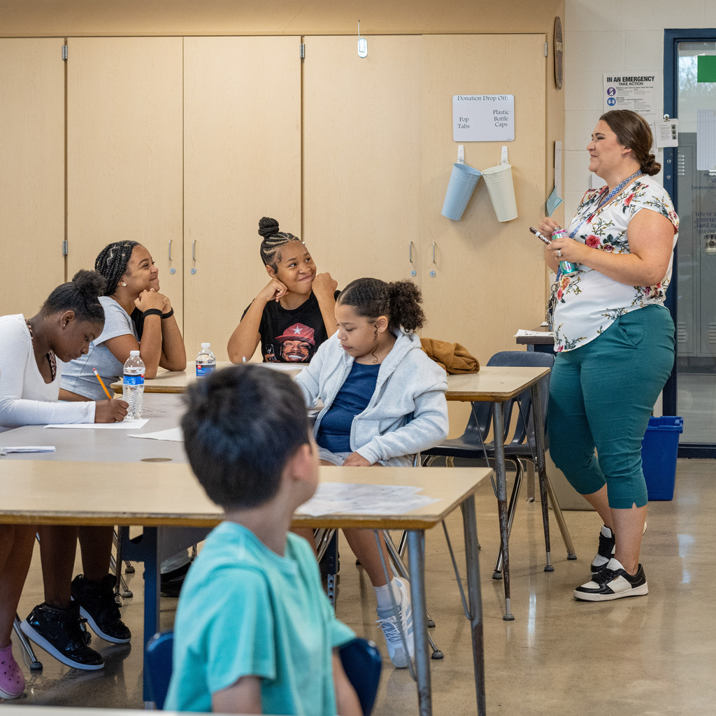 Students smiling at the teacher as they begin class.