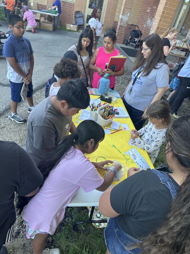 Kids gather around a table creating art