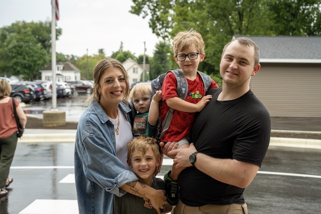 Family of five posing for photo as they drop off their preschooler.