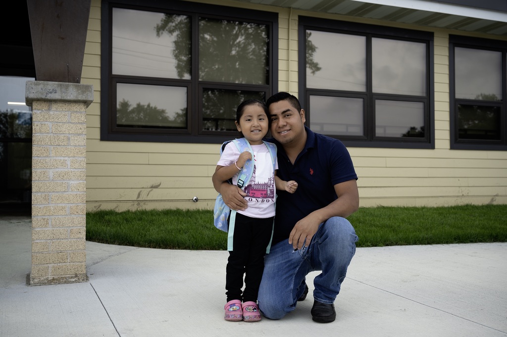 Dad and daughter posing outside of Mighty Oaks on the first day of school