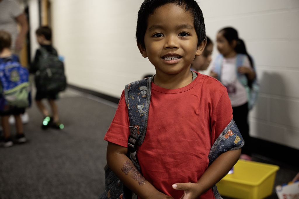Preschool student wearing their backpack outside of their classroom