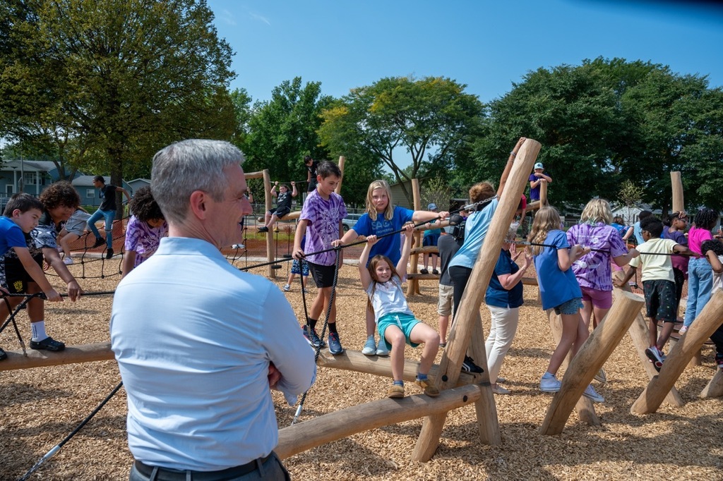 Superintendent Dr. Kent Pekel watches students enjoy the new park