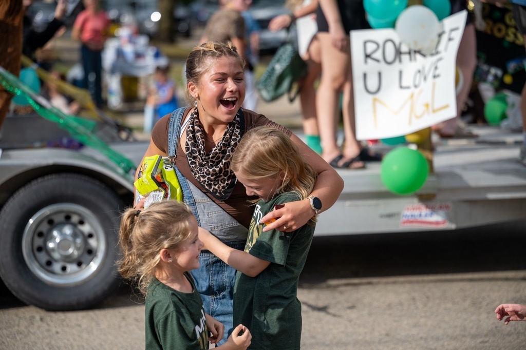 Mayo student sees some familiar faces in the parade crowd and gives them a hug