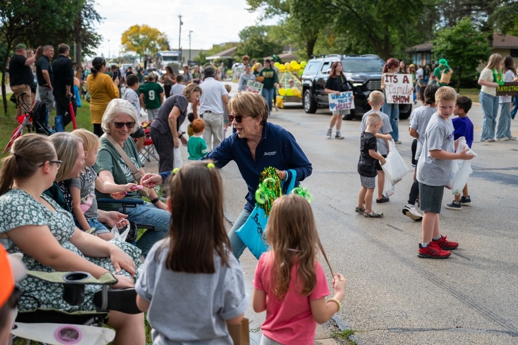 School board member Jean Marvin hands candy to parade watchers