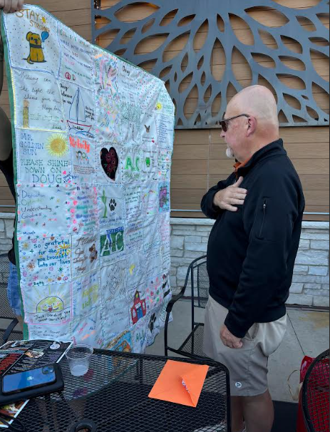 Doug receiving a quilt from staff and students