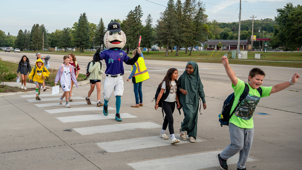 Rochester Honkers' Slider and Pinewood students safely cross a crosswalk.