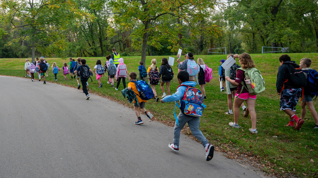 A long line of students walk and run in Bear Creek Park.