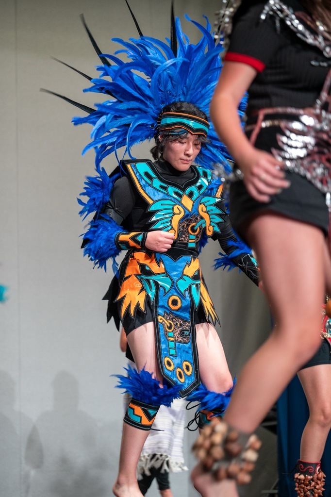 Aztec dancer watching the floor as they move into the next dance section