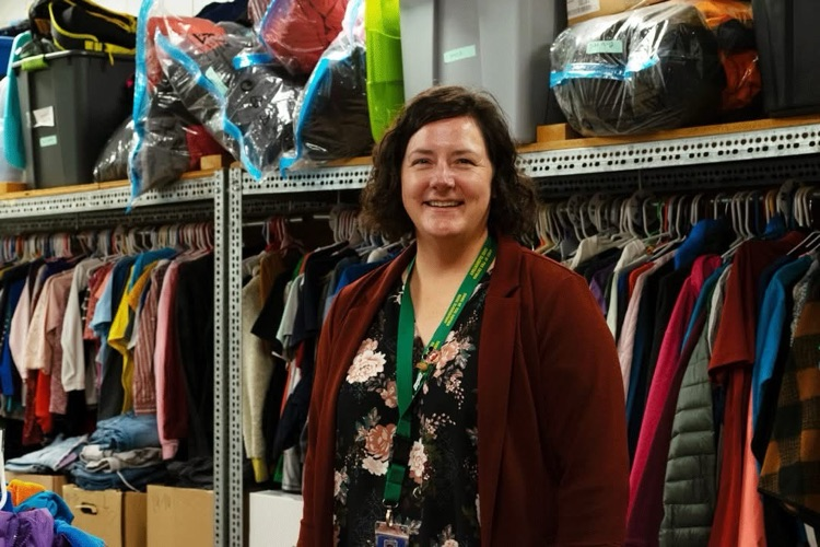Julie McLaren standing in front of the Gage clothing rack. 