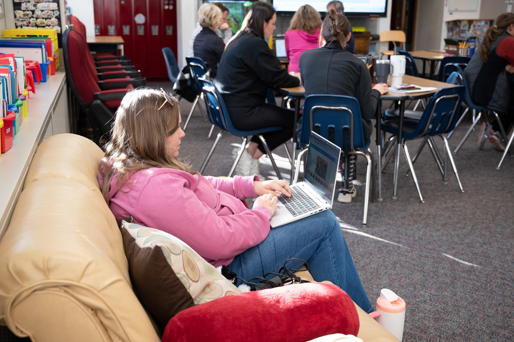 Teacher preps for parent-teacher conferences on her laptop.