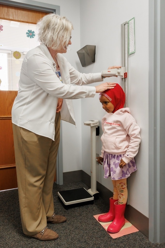 Screening teacher measuring three year old's height