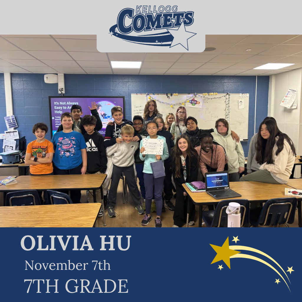 classroom of students in multicolored clothing, student in middle holding certificate for student of the week