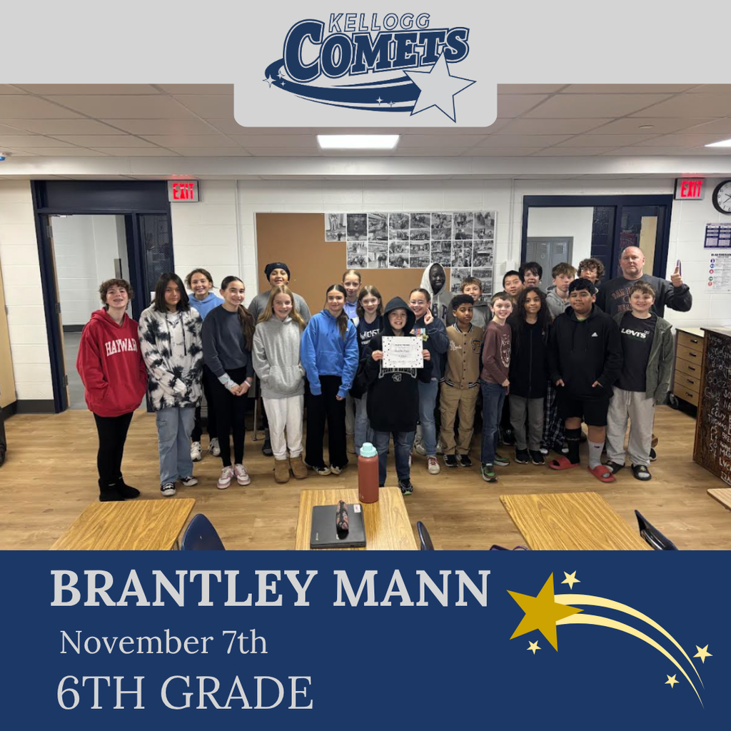classroom of students in multicolored clothing, student in middle holding certificate for student of the week