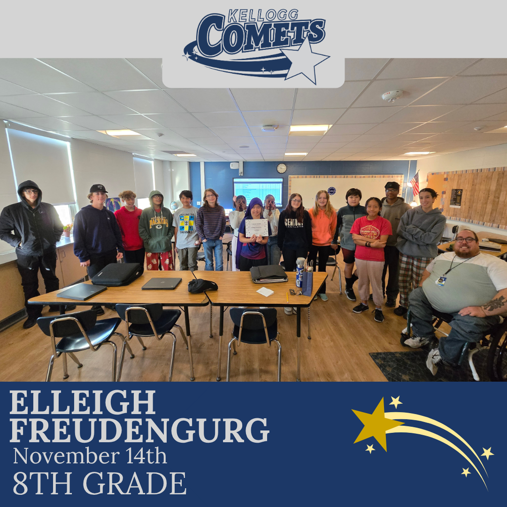 classroom of students in multicolored clothing, student in middle holding certificate for student of the week