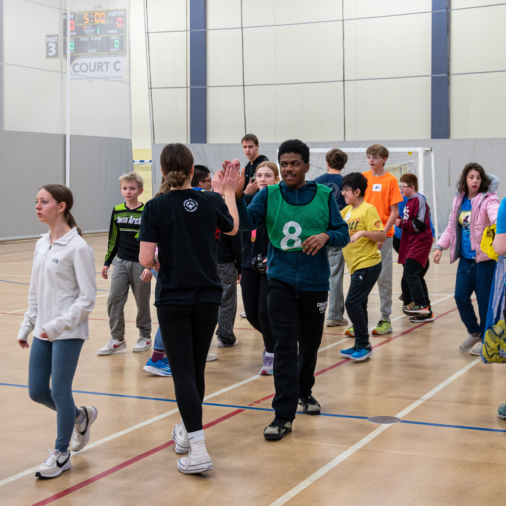 At the end of a soccer game, students line up and high-five the opposite team.
