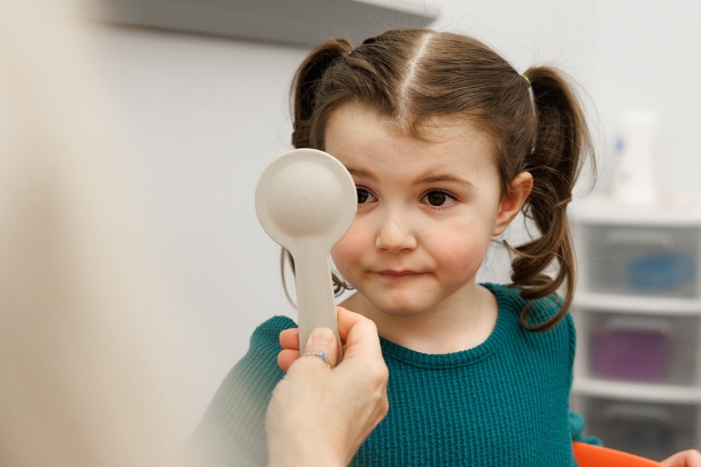girl having eyes checked to during an early childhood screening.