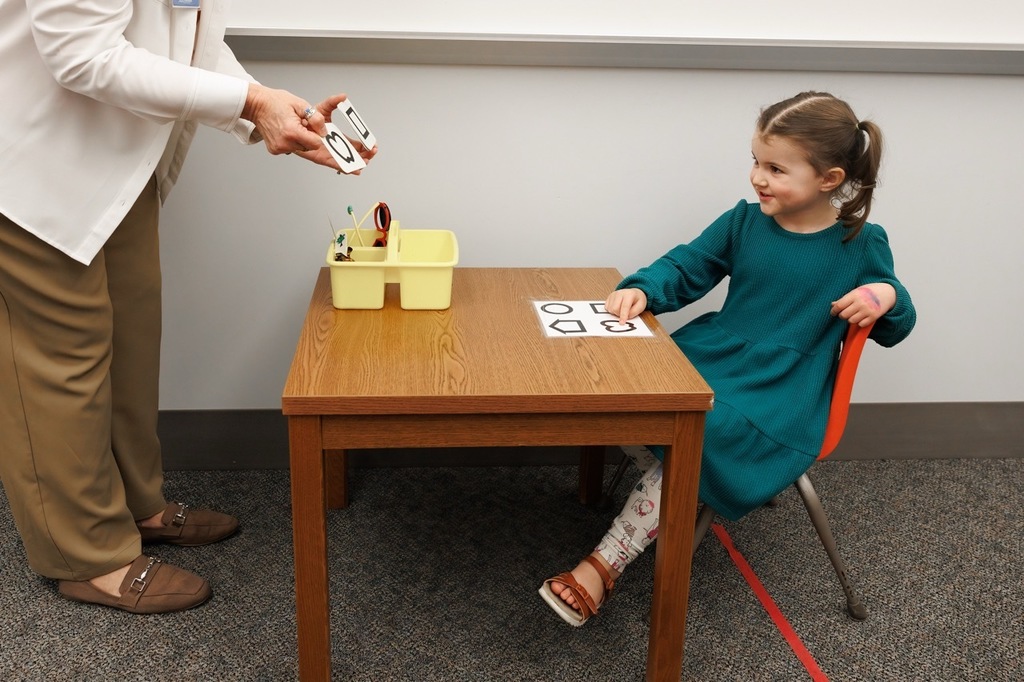 girl pointing to a shape when answering a question at an early childhood screening.