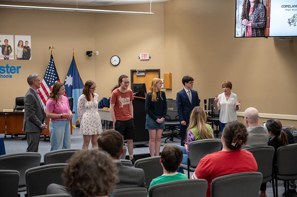 Students standing in front of the board room for their signing celebration with Jean Marvin.