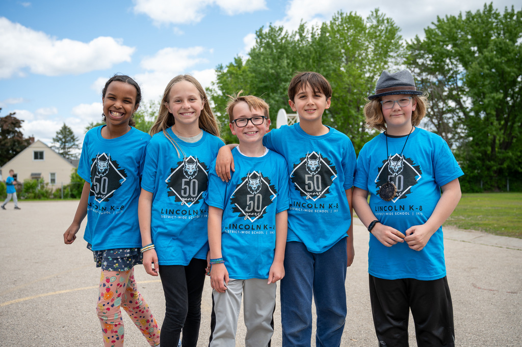 Five Lincoln students standing outside in a line in shirts that say Lincoln's 50th Celebration