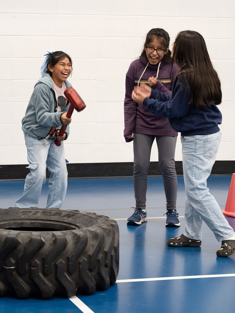 Middle schoolers laugh while learning about firefighting equipment.