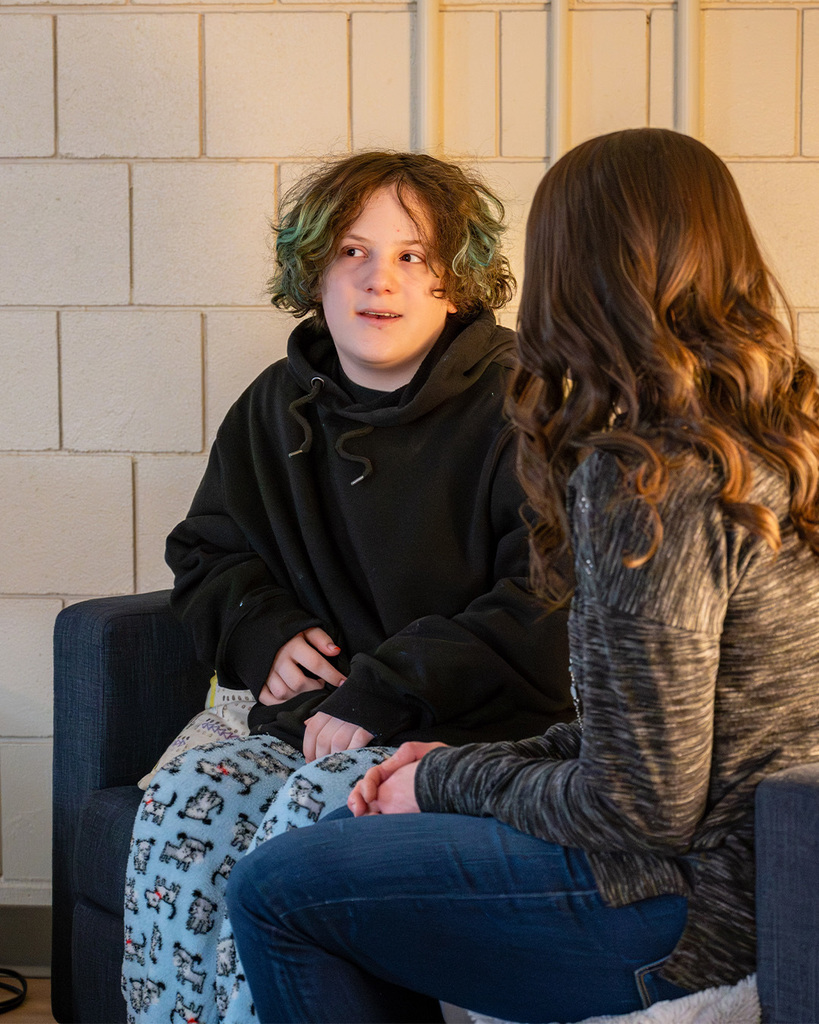 A student in conversation looks off to the side and smiles wistfully.