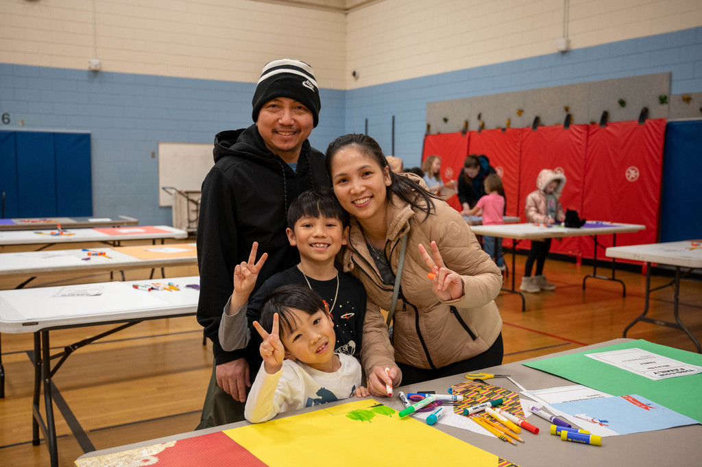 A family poses while crafting their family portrait