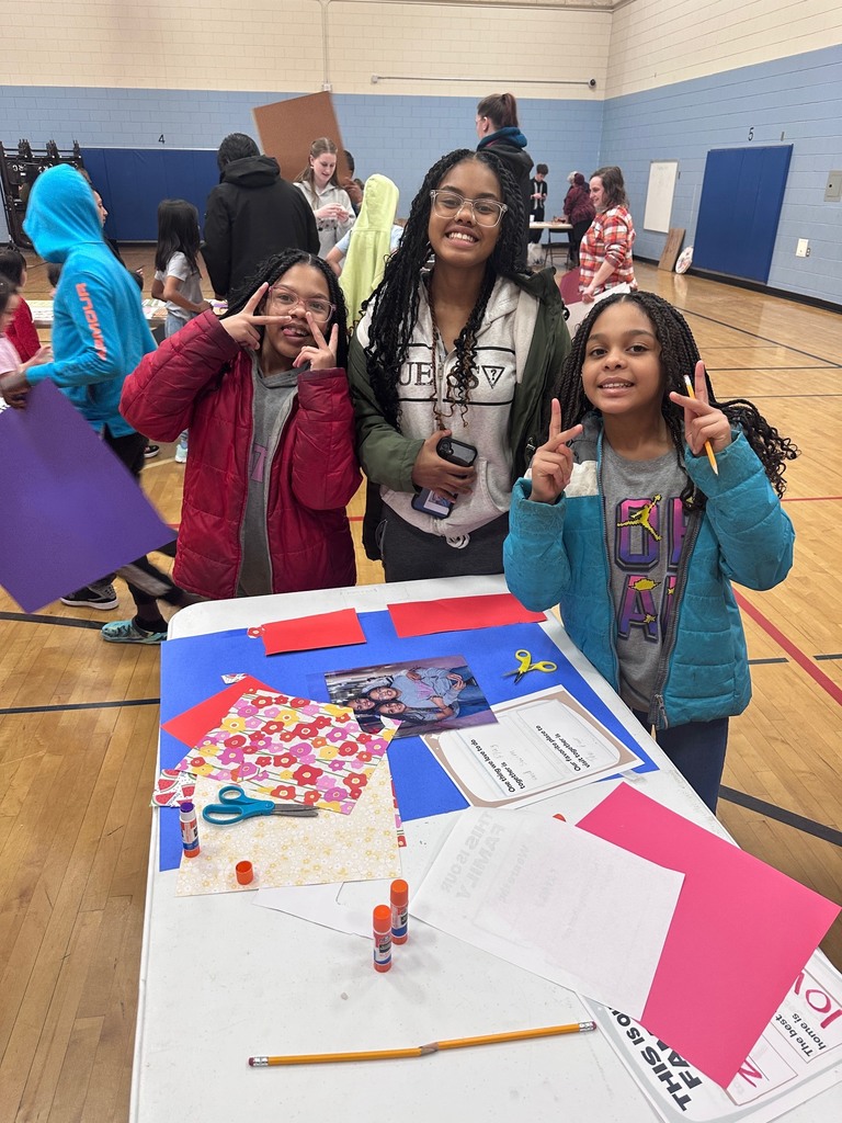 Family posing near the poster they are creating