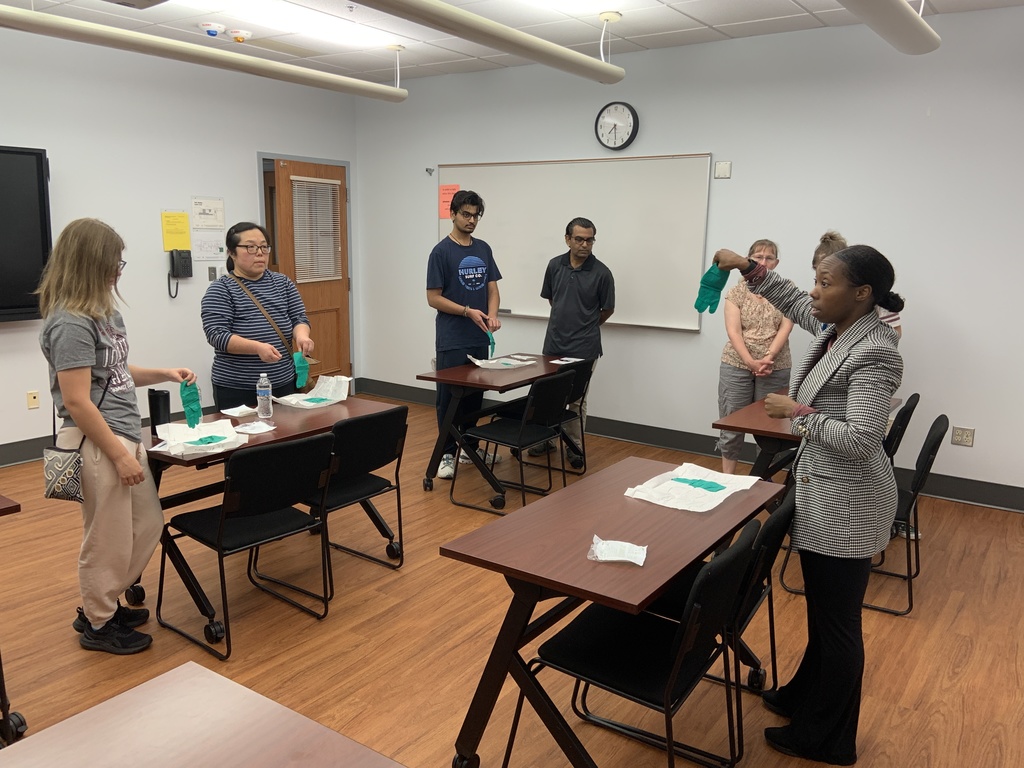 Instructor talking to staff about glove usage and health safety.