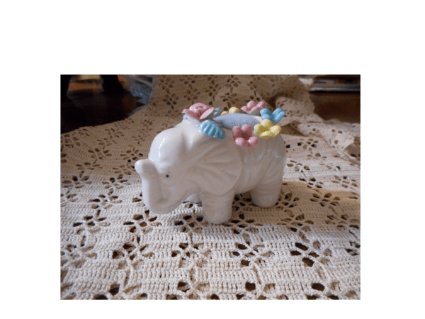 A white china elephant turned into a pincushion.