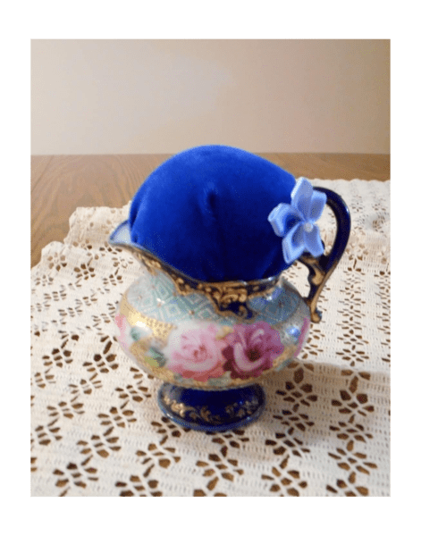 A cream pitcher turned into a pincushion.