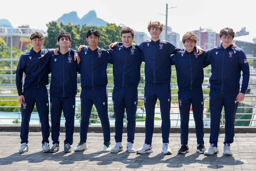Team USA Men's Epee linked with arms behind the shoulders smiling at the camera.