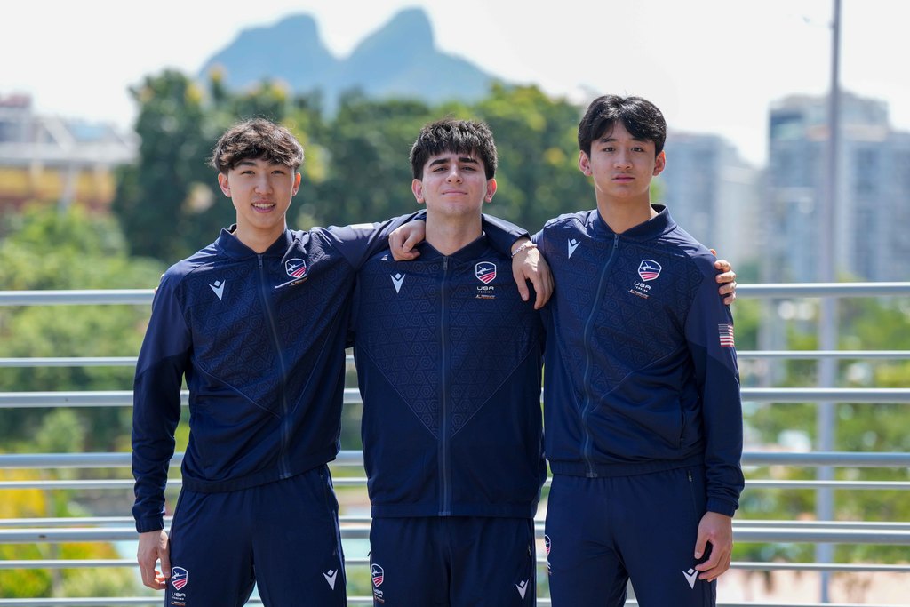 Andy Zheng featured on right with two other teammates locked in arms looking at the camera.