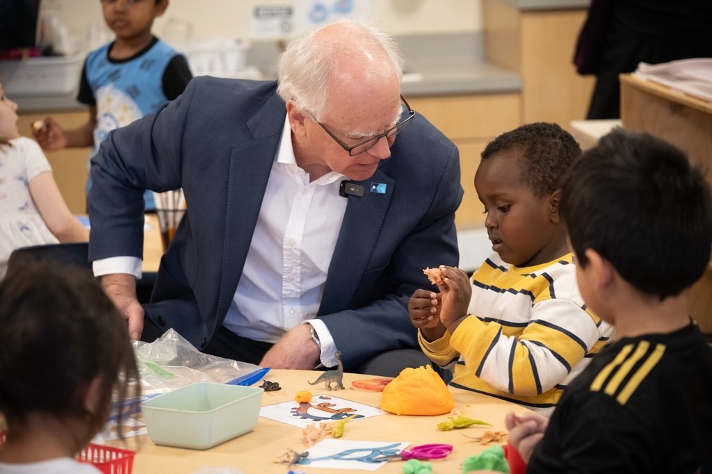Governor Tim Walz talking to a preschool student about what type of dinosaur he is working with.