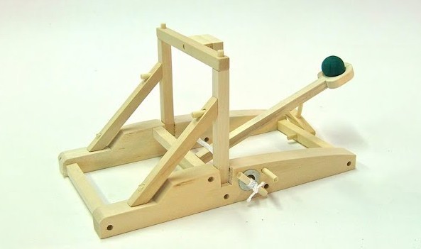 a small wooden catapault loaded with a rock