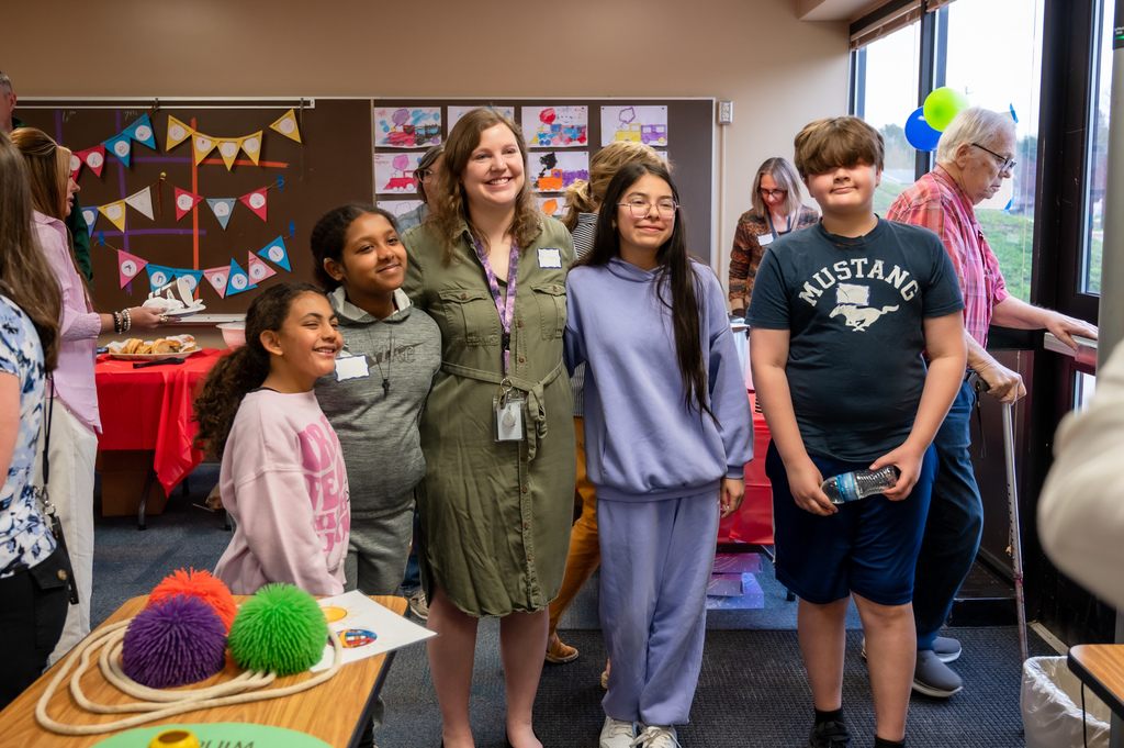 Students and their teacher smile for the camera.