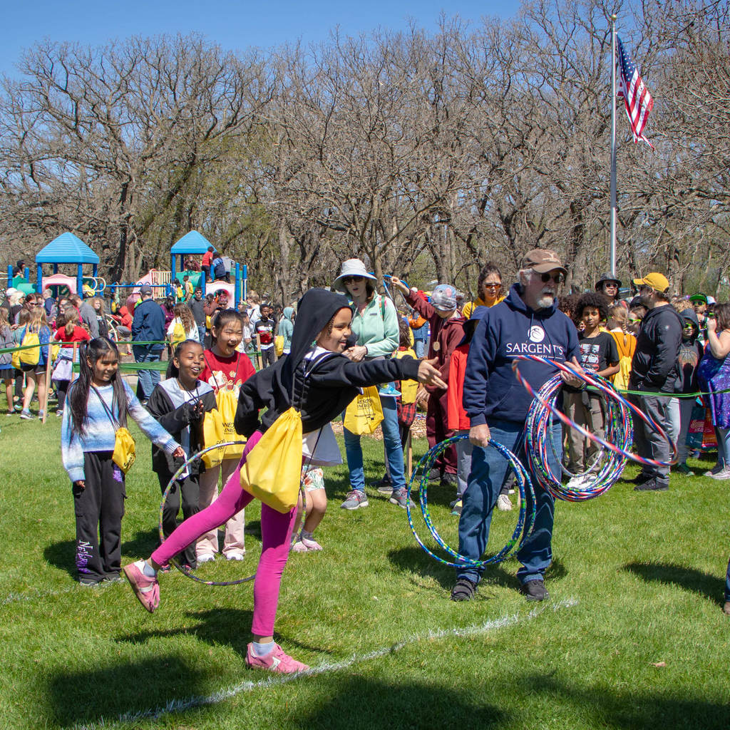 Kids enjoy a ring toss with hula hoops at the park.