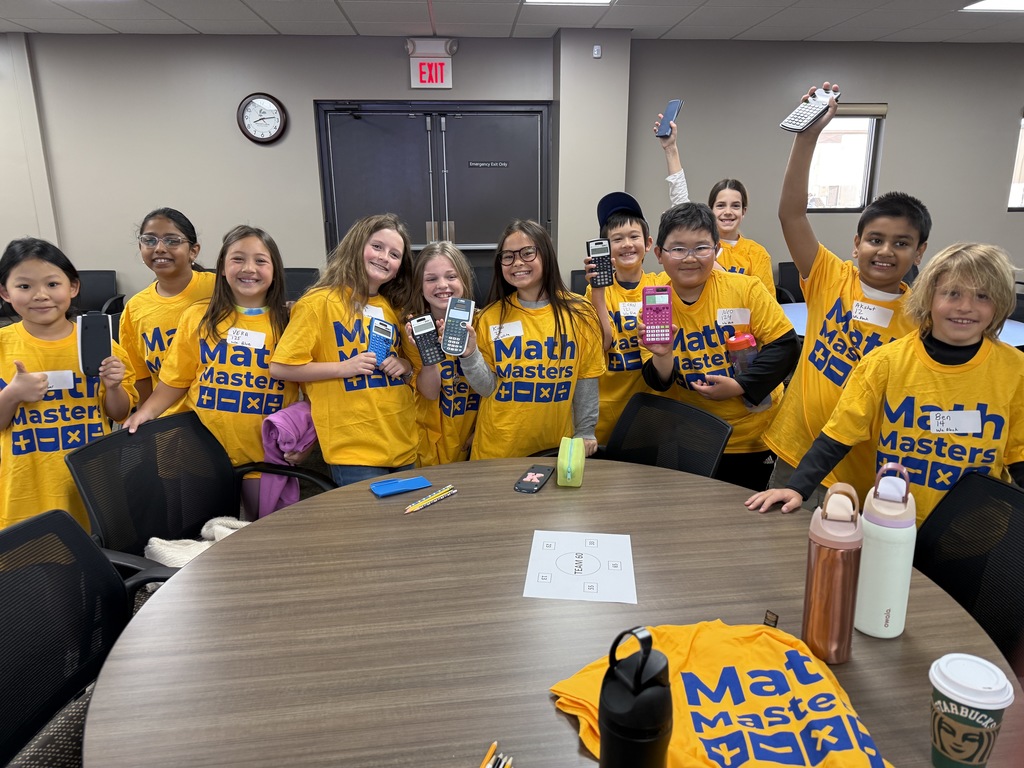 Group of 11 4th Grade Math Masters holding up their calculators and smiling at the camera as they get ready to compete.
