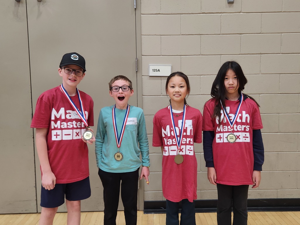 Four Math Master students standing in a row wearing their medals for placing.