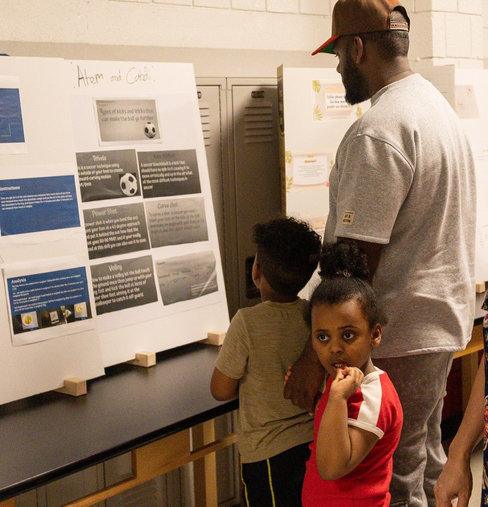 dad and two children looking at projects